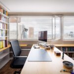 Bright modern office with bookshelves and cityscape view in Bogotá.